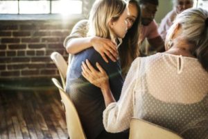 group therapy session consoling woman