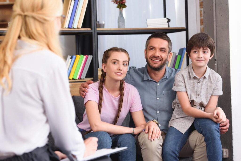 two young people and a parent speak with a counselor about achieving family therapy goals