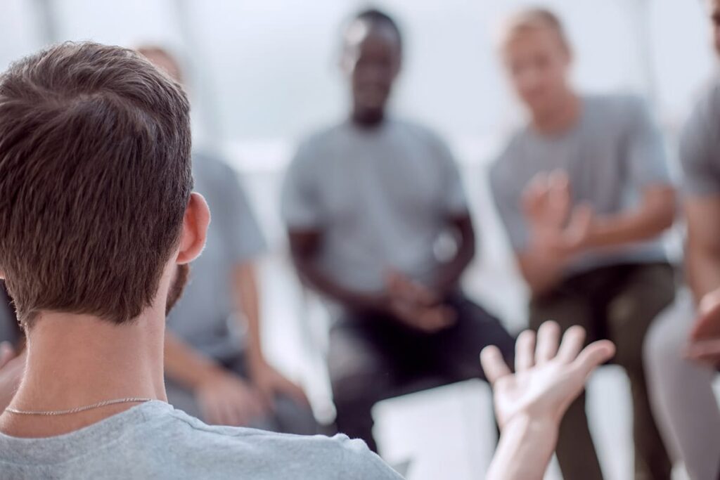 men talk together in group therapy at a mens rehab center