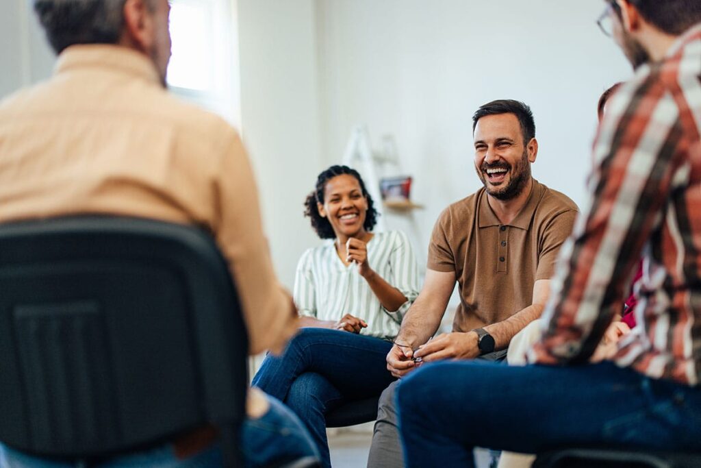 a group of people sitting in chairs learns about group therapy stages