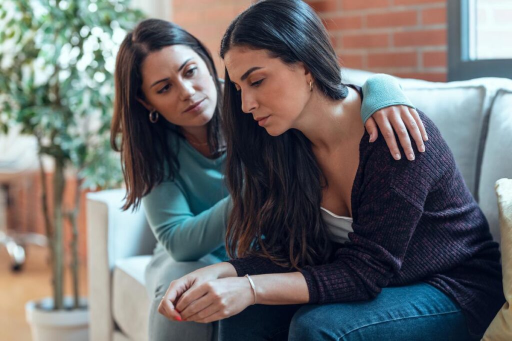 a person wraps their arms around their alcoholic loved one