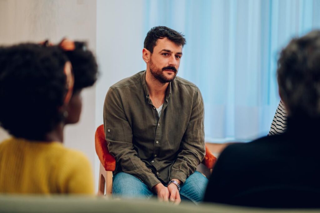a man participates in group therapy as part of a ptsd treatment program