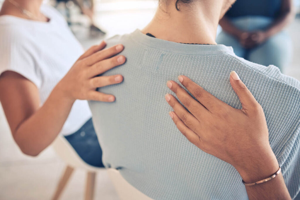 people put hands on the shoulders of a person after choosing the right alcohol treatment
