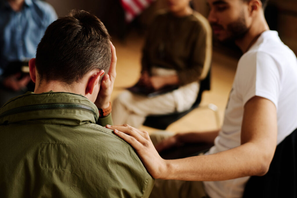 A group of people in therapy discuss signs of PTSD