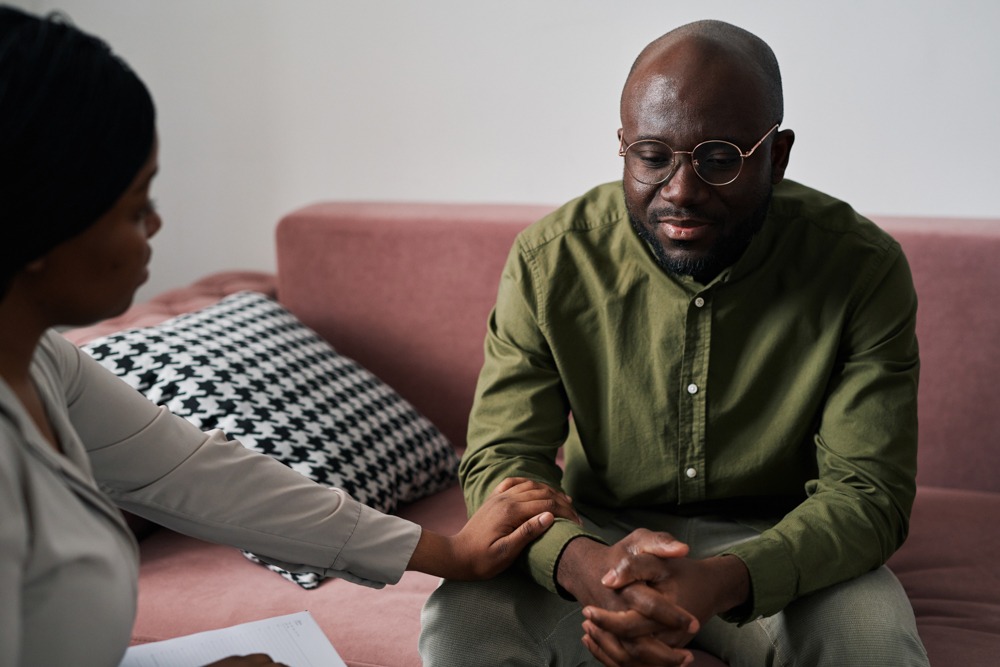 a man being comforted by therapist in cbt for alcohol use disorder