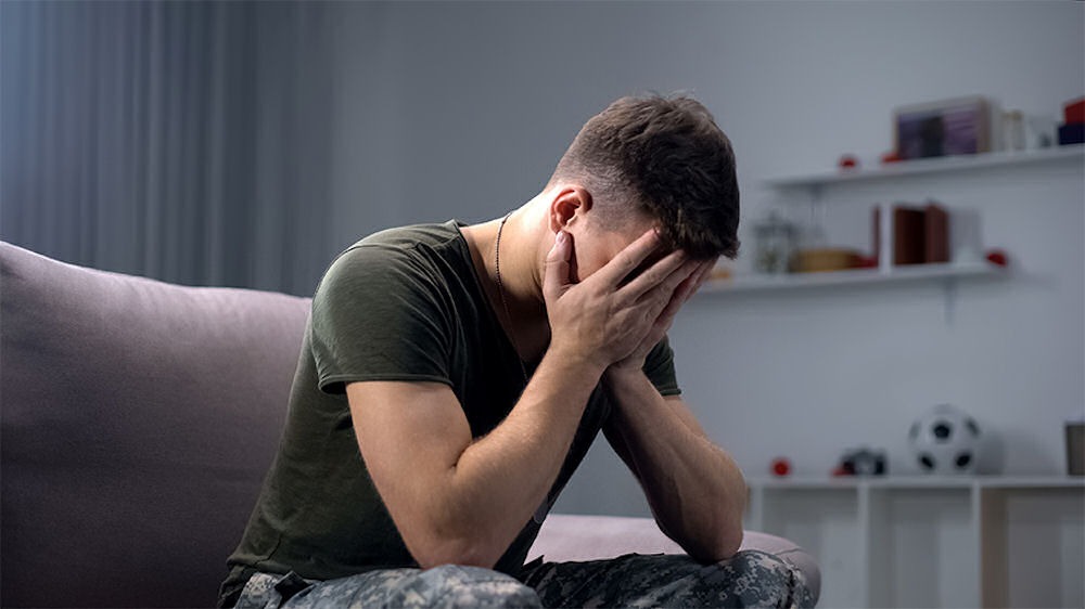 a veteran with face in hands in therapy